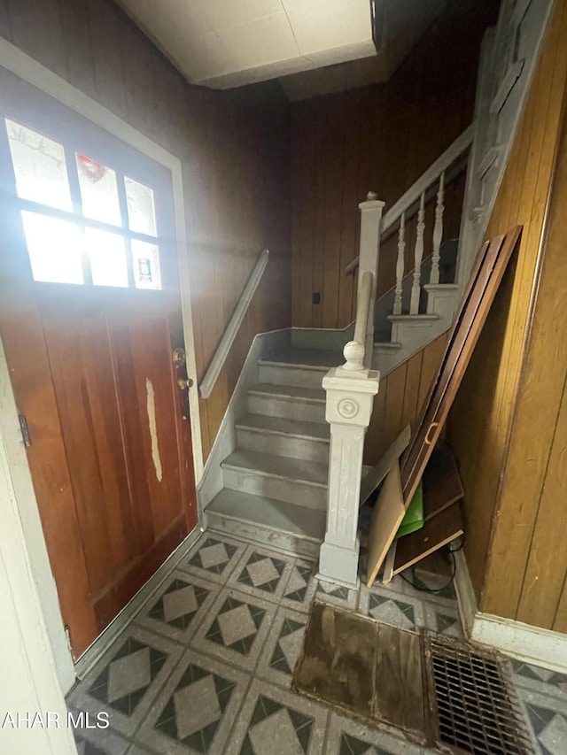 entryway featuring wood walls and stairway