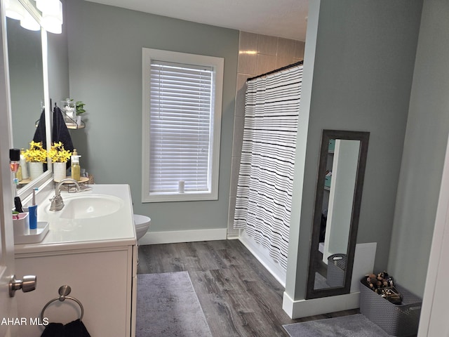 bathroom with vanity, hardwood / wood-style flooring, toilet, and curtained shower