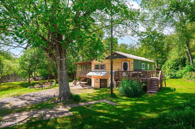 view of front of home featuring a wooden deck, a fire pit, and a front yard