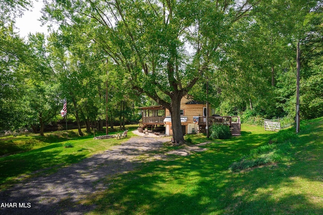 view of front of home featuring a front lawn and a wooden deck