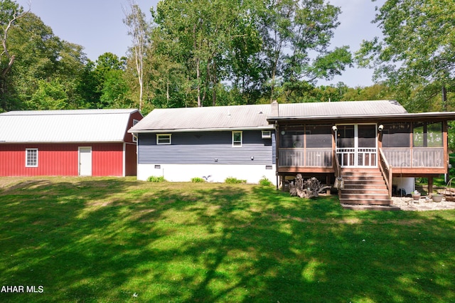 rear view of house featuring a sunroom and a yard