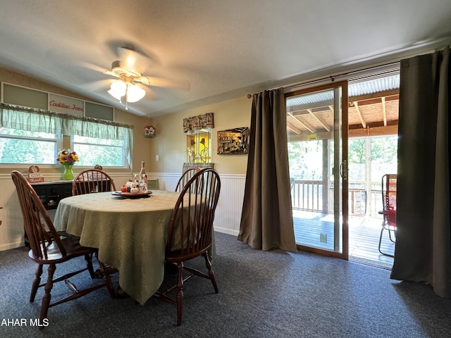 carpeted dining area with ceiling fan and lofted ceiling