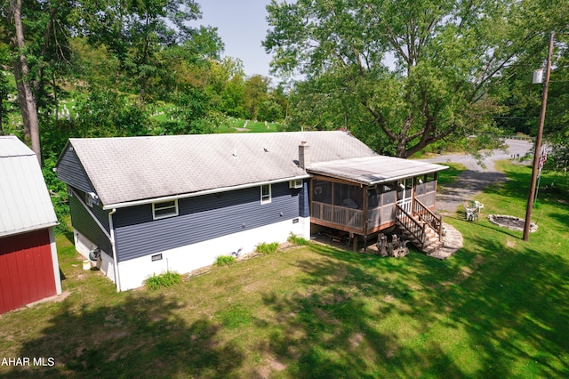 back of house with a lawn and a sunroom