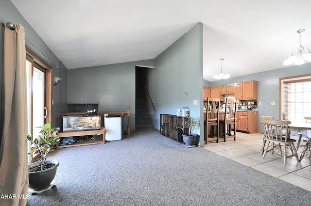 living area featuring light tile patterned floors, light carpet, an inviting chandelier, and vaulted ceiling