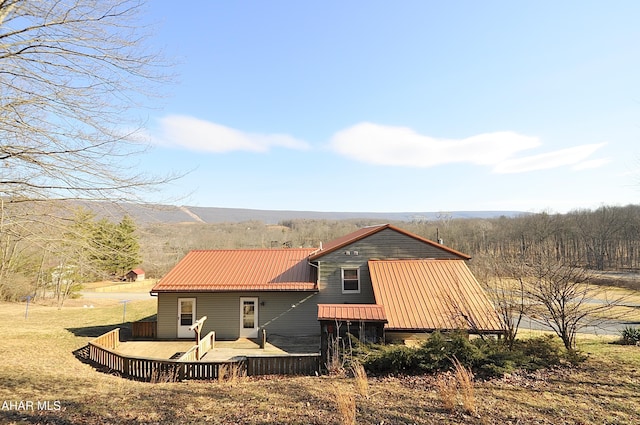 rear view of house with metal roof and a deck