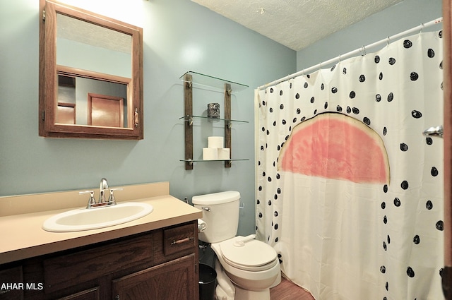 full bath with curtained shower, toilet, vanity, wood finished floors, and a textured ceiling