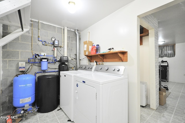 clothes washing area featuring laundry area, concrete block wall, and separate washer and dryer