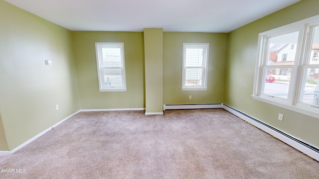 carpeted spare room with baseboards and a baseboard heating unit