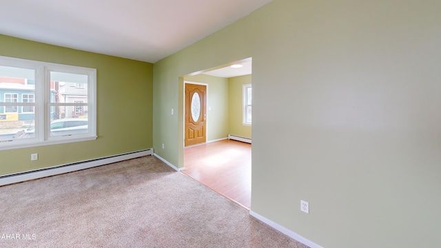 foyer entrance with a baseboard heating unit, baseboards, and carpet floors