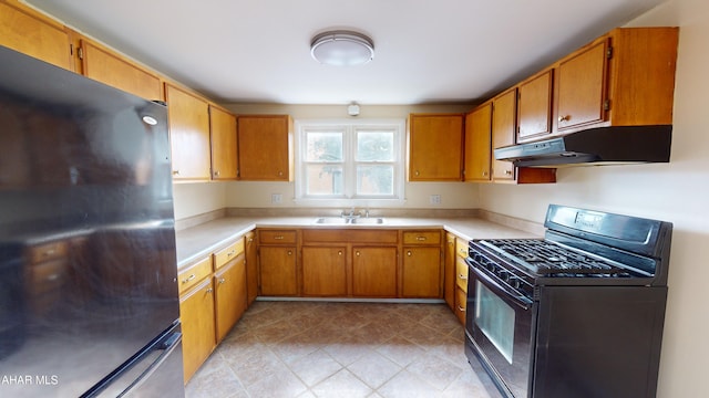 kitchen featuring a sink, light countertops, black appliances, and under cabinet range hood