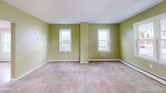 empty room featuring a baseboard radiator, plenty of natural light, carpet, and baseboard heating