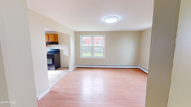 interior space featuring a baseboard heating unit and light wood finished floors
