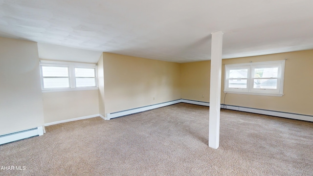 basement with carpet flooring, baseboard heating, baseboards, and a healthy amount of sunlight