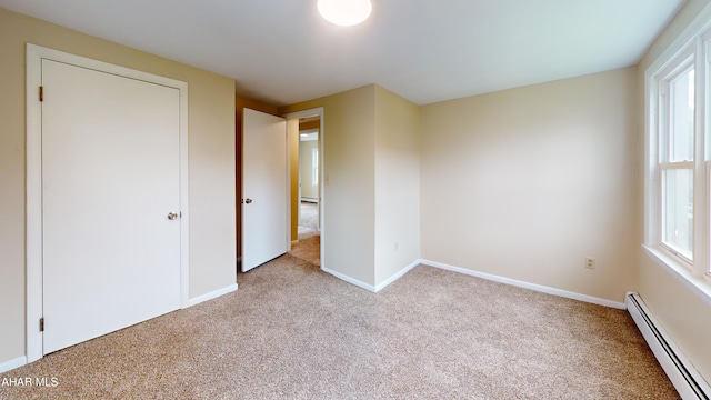 unfurnished bedroom featuring carpet, a baseboard radiator, and baseboards