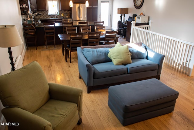 living room with light hardwood / wood-style flooring and sink