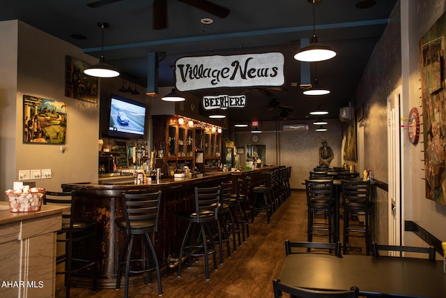 bar featuring ceiling fan, dark hardwood / wood-style flooring, and decorative light fixtures