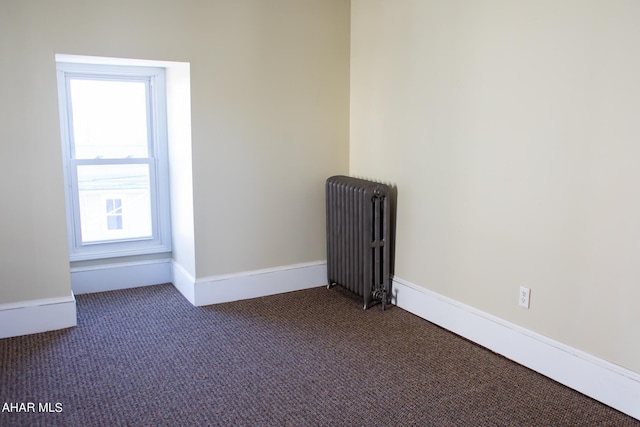 carpeted empty room featuring radiator