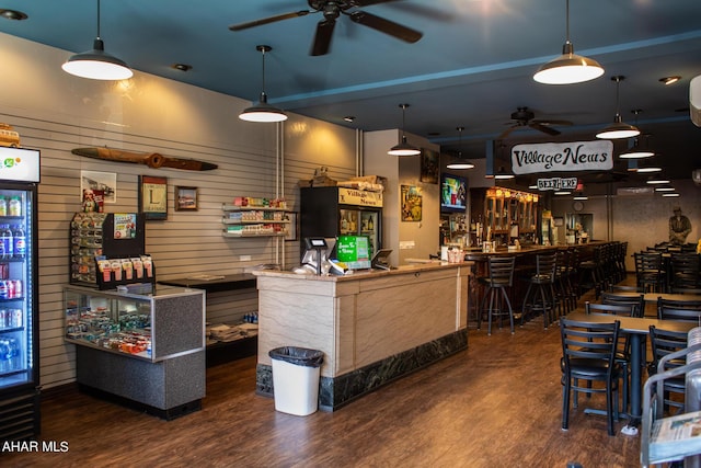 bar with ceiling fan, dark wood-type flooring, and wood walls