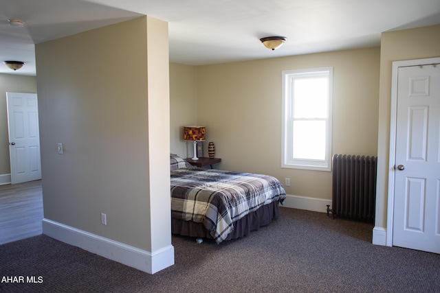 bedroom with dark colored carpet and radiator heating unit