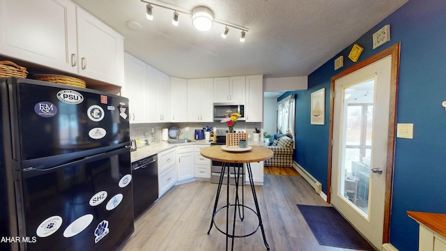 317 Tree Ln, Duncansville, PA 16635 - kitchen with white cabinetry, a baseboard heating unit, light hardwood / wood-style flooring, and black appliances