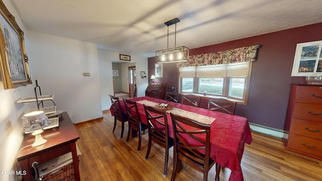 dining space featuring hardwood / wood-style flooring and a baseboard heating unit