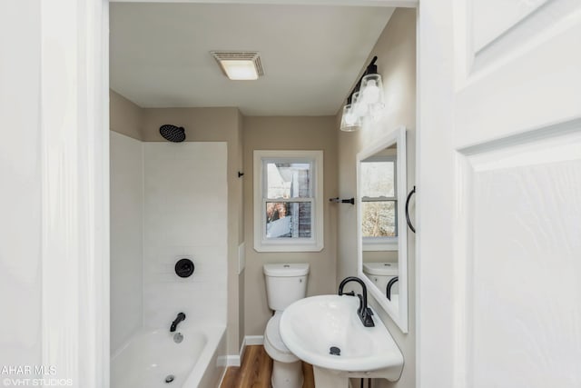 full bathroom featuring hardwood / wood-style flooring, tub / shower combination, toilet, and sink