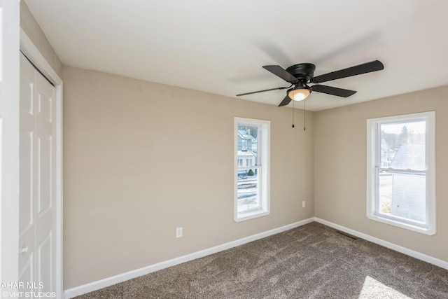 carpeted spare room featuring ceiling fan