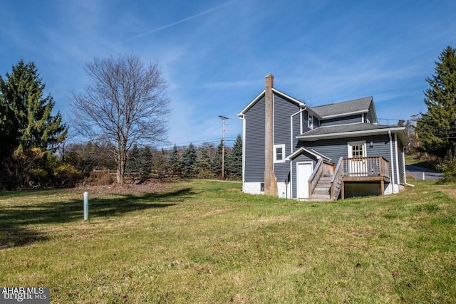 back of property featuring a lawn, a chimney, and a shingled roof