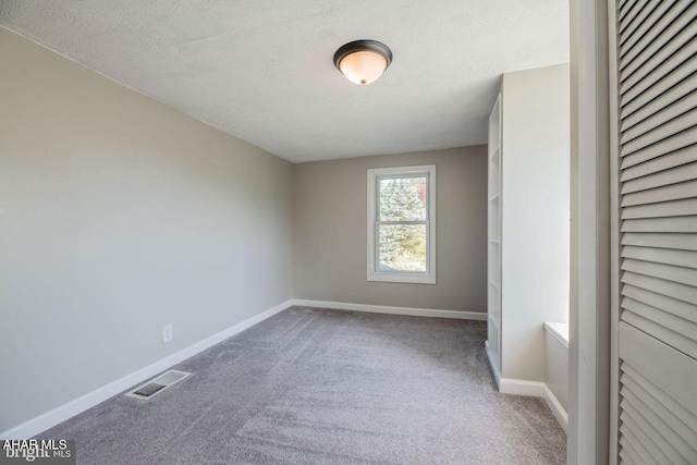 unfurnished bedroom with visible vents, baseboards, a textured ceiling, and carpet floors