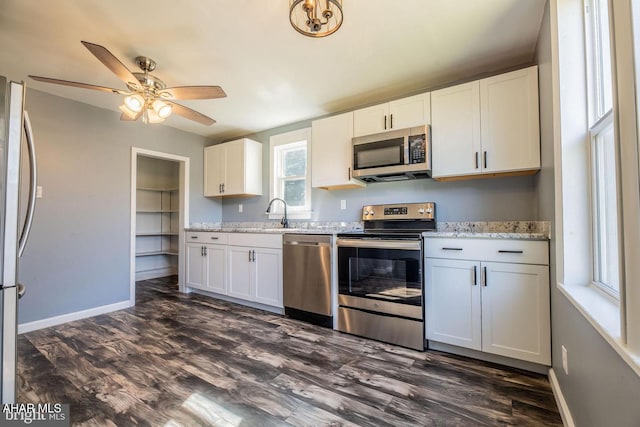 kitchen featuring dark wood-style floors, appliances with stainless steel finishes, and baseboards