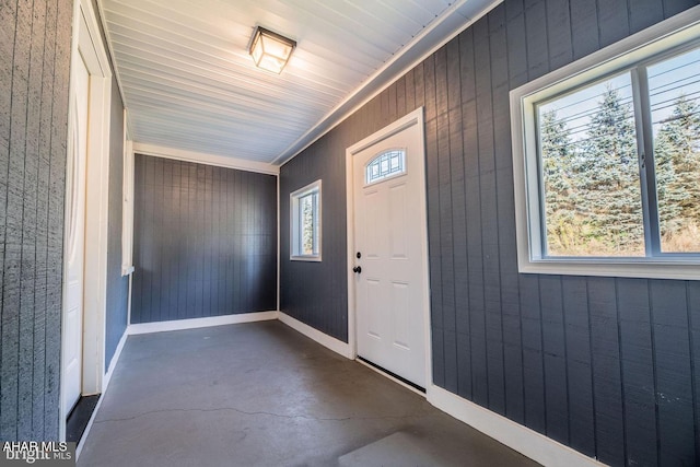 entrance foyer featuring plenty of natural light, baseboards, and concrete floors