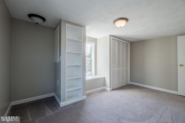 unfurnished bedroom with a closet, baseboards, a textured ceiling, and carpet flooring