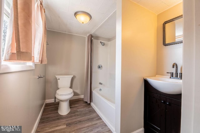 bathroom with vanity, wood finished floors, baseboards, shower / bath combination with curtain, and toilet