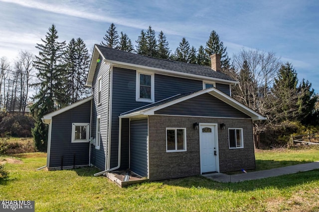 view of front of property featuring a chimney and a front yard