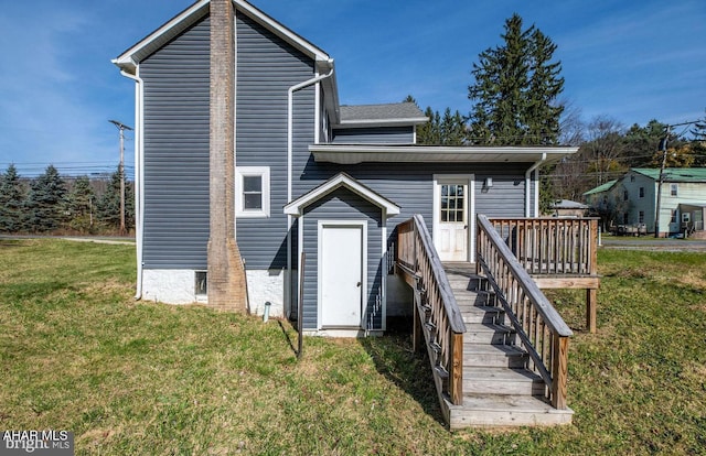 back of property featuring a lawn, a deck, and stairs