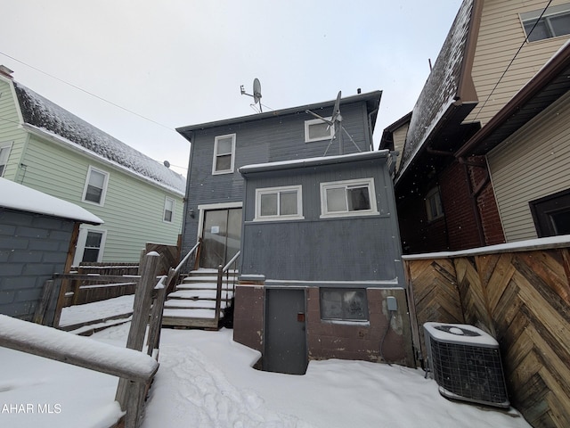 snow covered property featuring central air condition unit