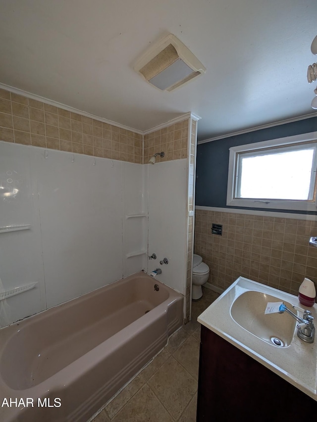 full bathroom with tile patterned floors, toilet, shower / bathing tub combination, tile walls, and vanity