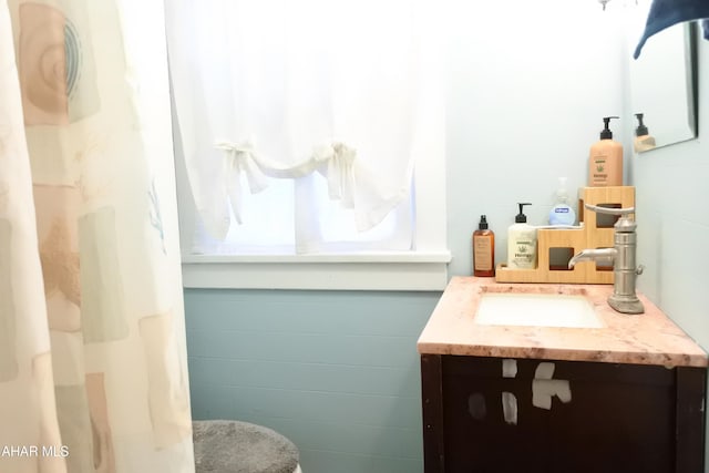 bathroom with vanity and tile walls