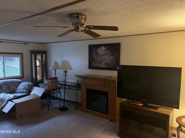 living room featuring carpet flooring, ceiling fan, and a textured ceiling