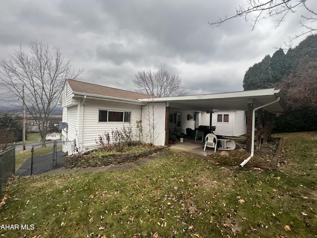 rear view of house featuring a yard and a carport