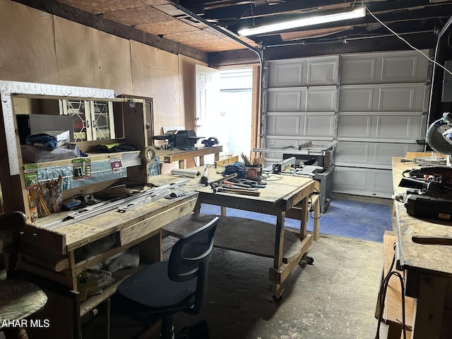 garage with a workshop area and wooden walls