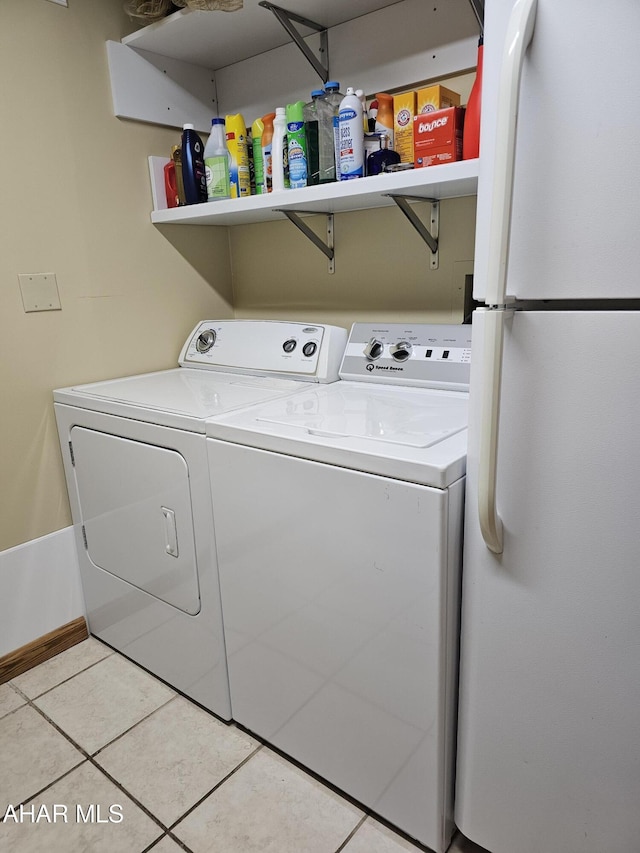 laundry room featuring light tile patterned floors and washer and clothes dryer