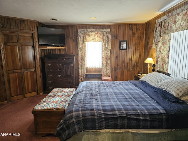 bedroom featuring dark carpet, wooden walls, and ornamental molding