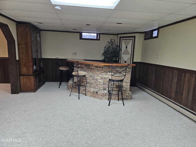 bar featuring a baseboard radiator, a paneled ceiling, light colored carpet, and dark brown cabinets