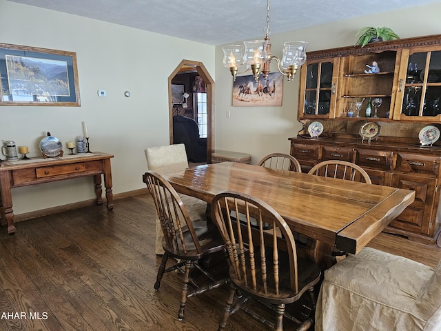 dining room featuring dark hardwood / wood-style floors, a textured ceiling, and a notable chandelier