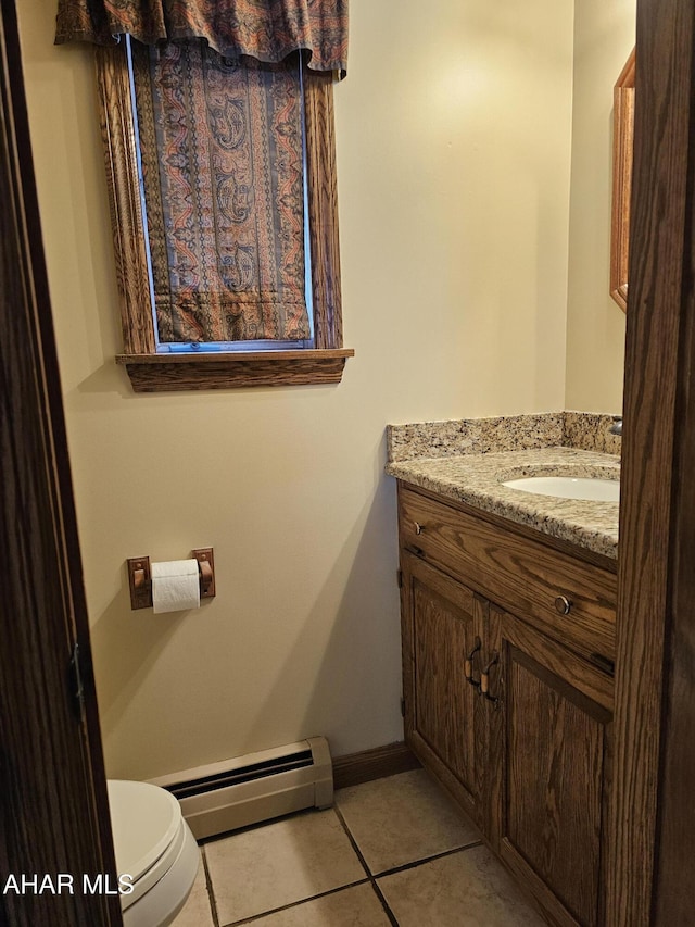 bathroom featuring tile patterned flooring, vanity, toilet, and baseboard heating