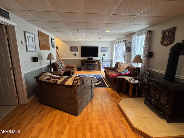 153 Frederick Rd, Altoona, PA 16602 - living area with light wood finished floors, a drop ceiling, a wood stove, and baseboards
