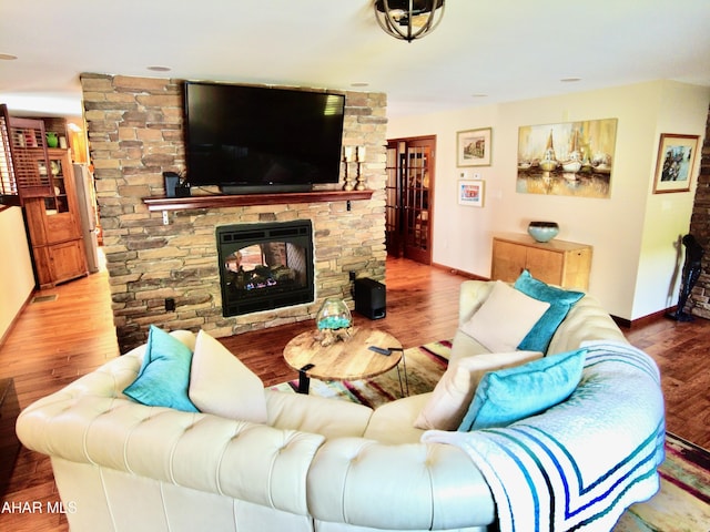 living room featuring hardwood / wood-style floors and a stone fireplace