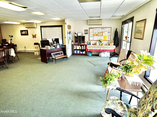 living room with a wall mounted air conditioner, a drop ceiling, and carpet