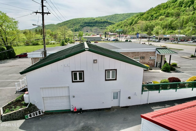 view of property exterior featuring a mountain view and a garage